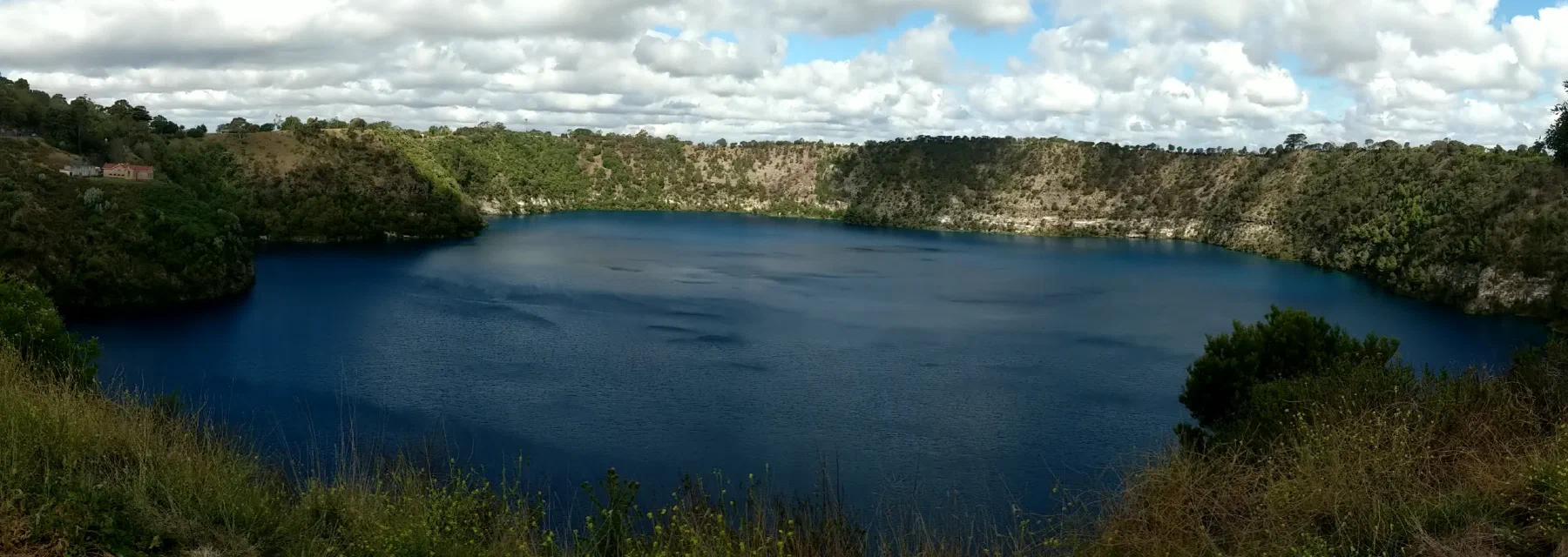 A panorama of the Blue Lake's vivid turquoise water inside its volcanic crater, Mount Gambier